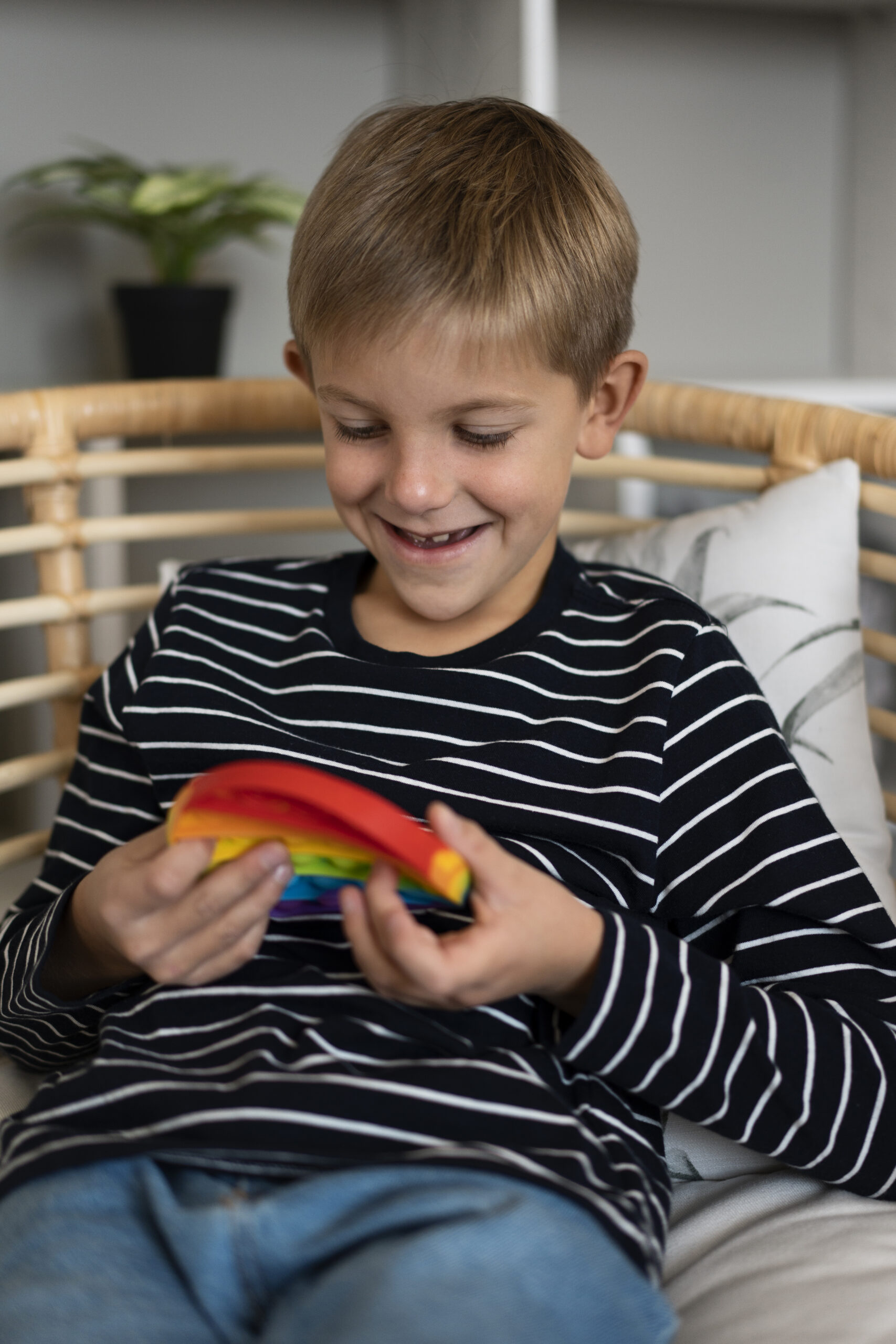 Young boy playing with a sensory toy and smiling.